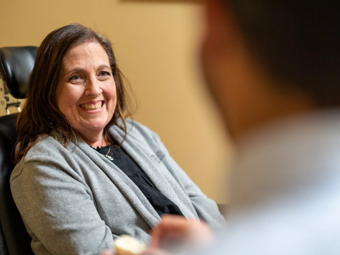 Patient smiling in an exam chair during a consultation.