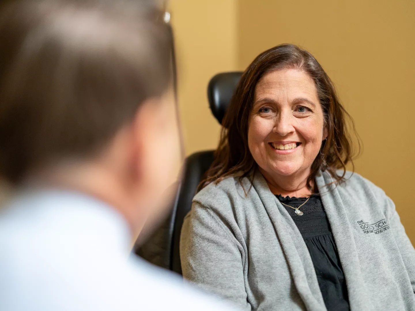 Dr. Clark speaks with a smiling patient in an exam room.