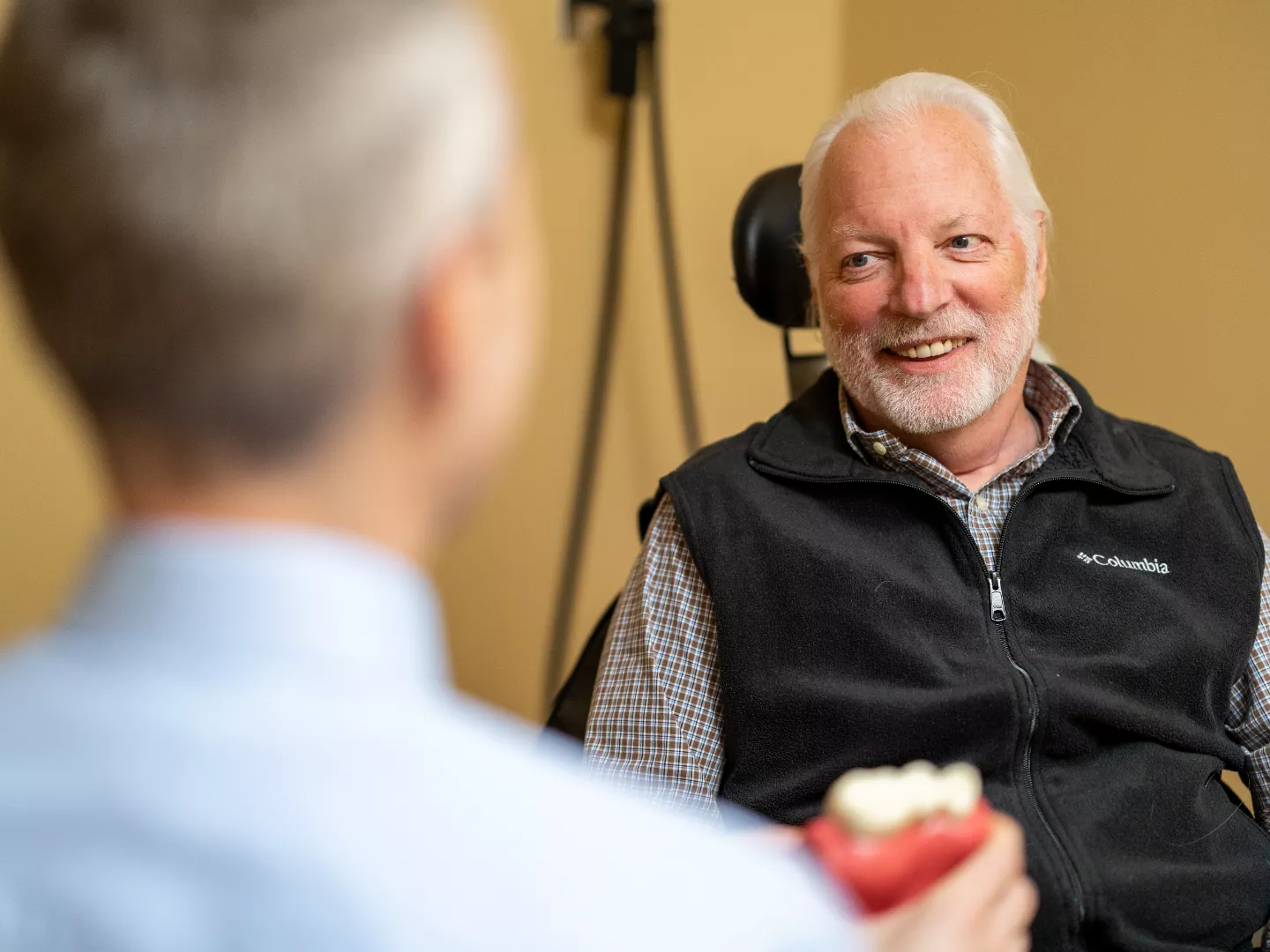 Dr. Young showing an implant model to a patient during a consult.