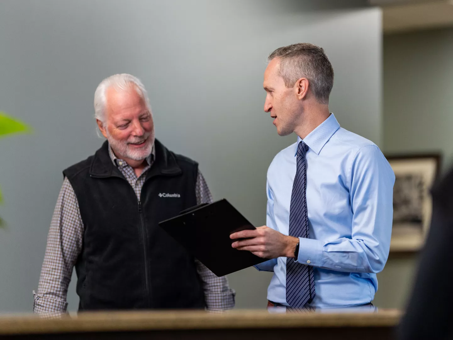 Dr. Young talking with a patient holding a clipboard.