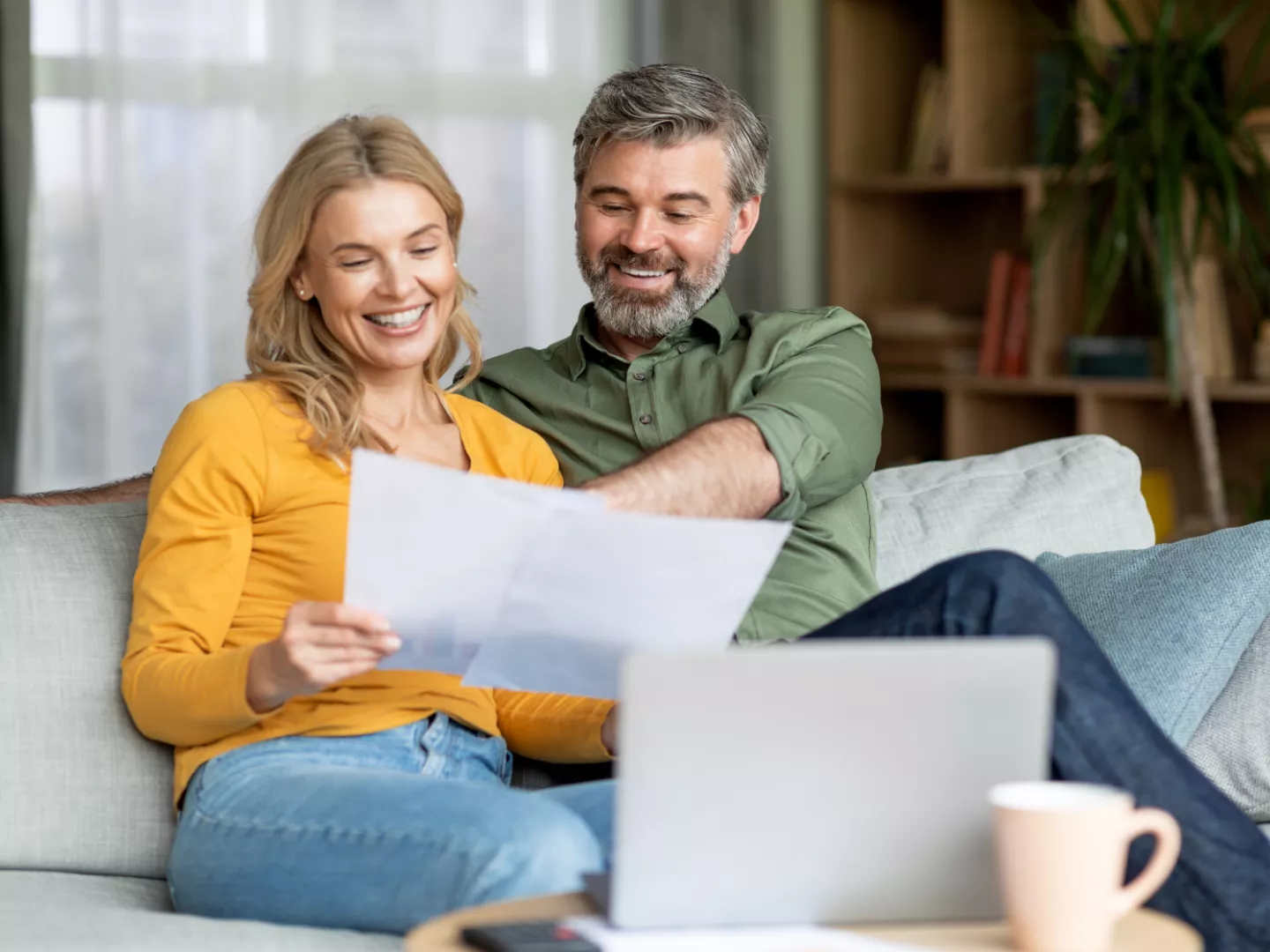 Couple going over options with a laptop comfortably at home.