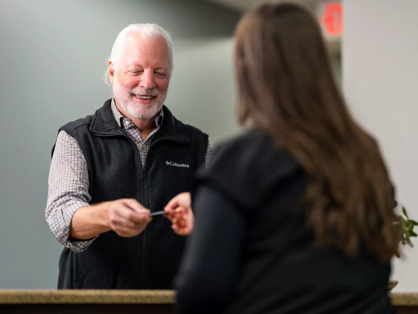 Team member interacting with patient at reception.