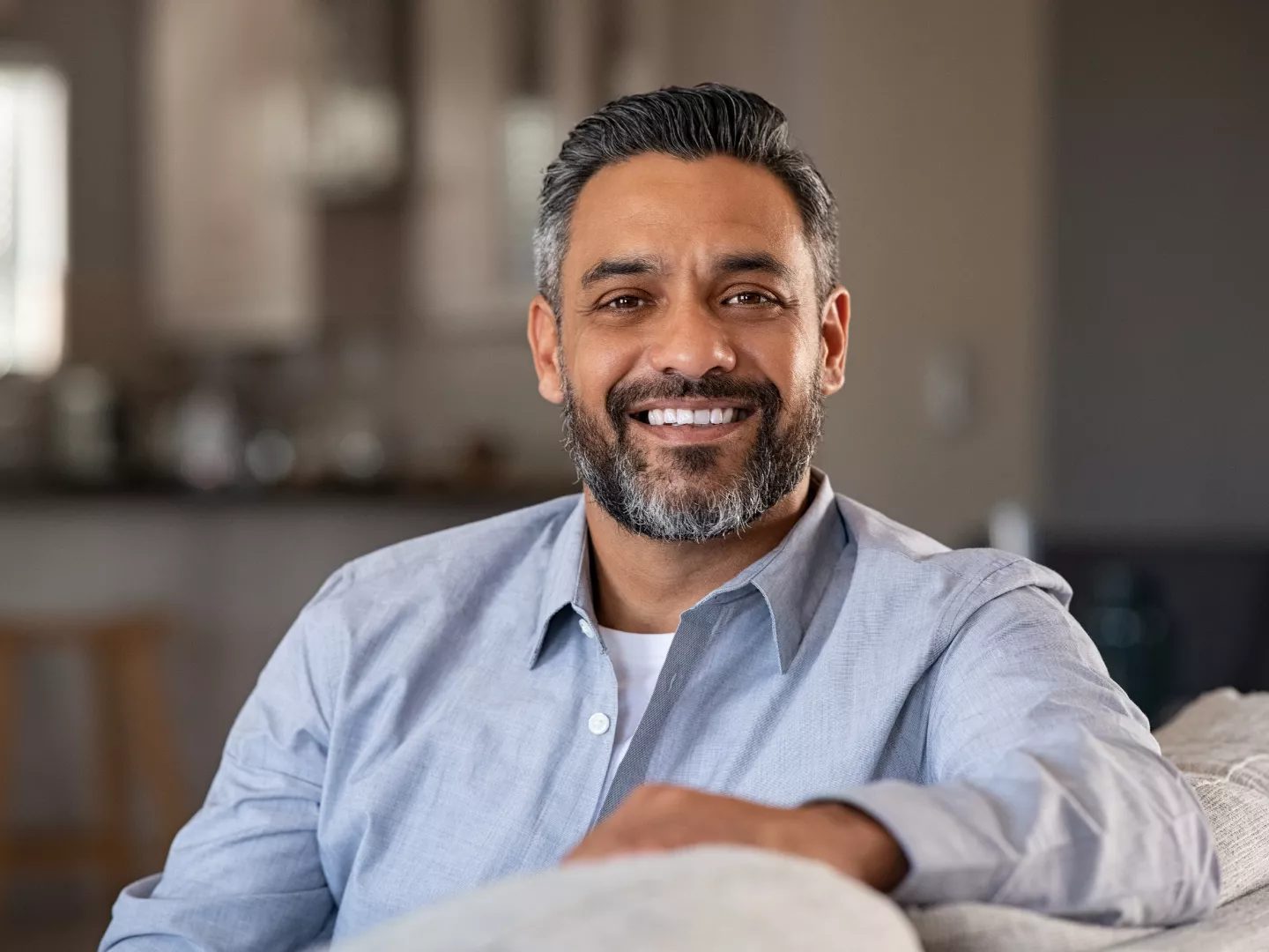 A man smiling comfortably at home.