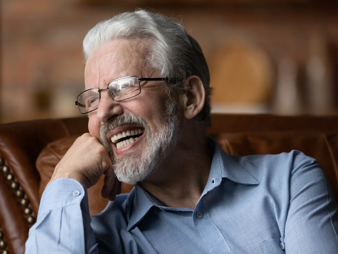 A man smiling comfortably at home.