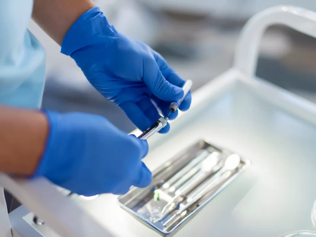 A dental professional preparing an injection.
