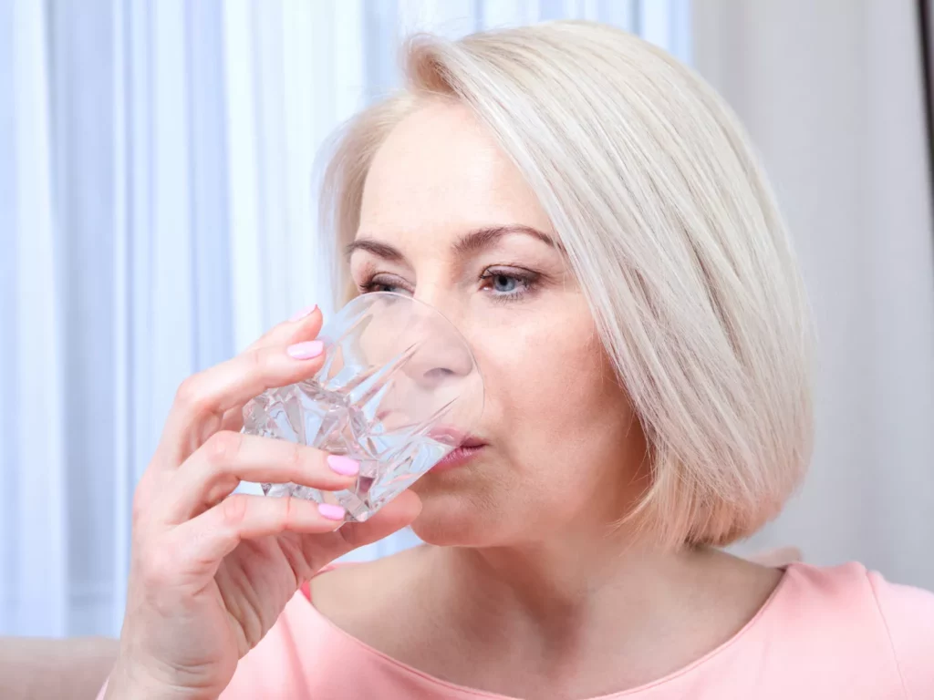 A woman drinking a glass of water