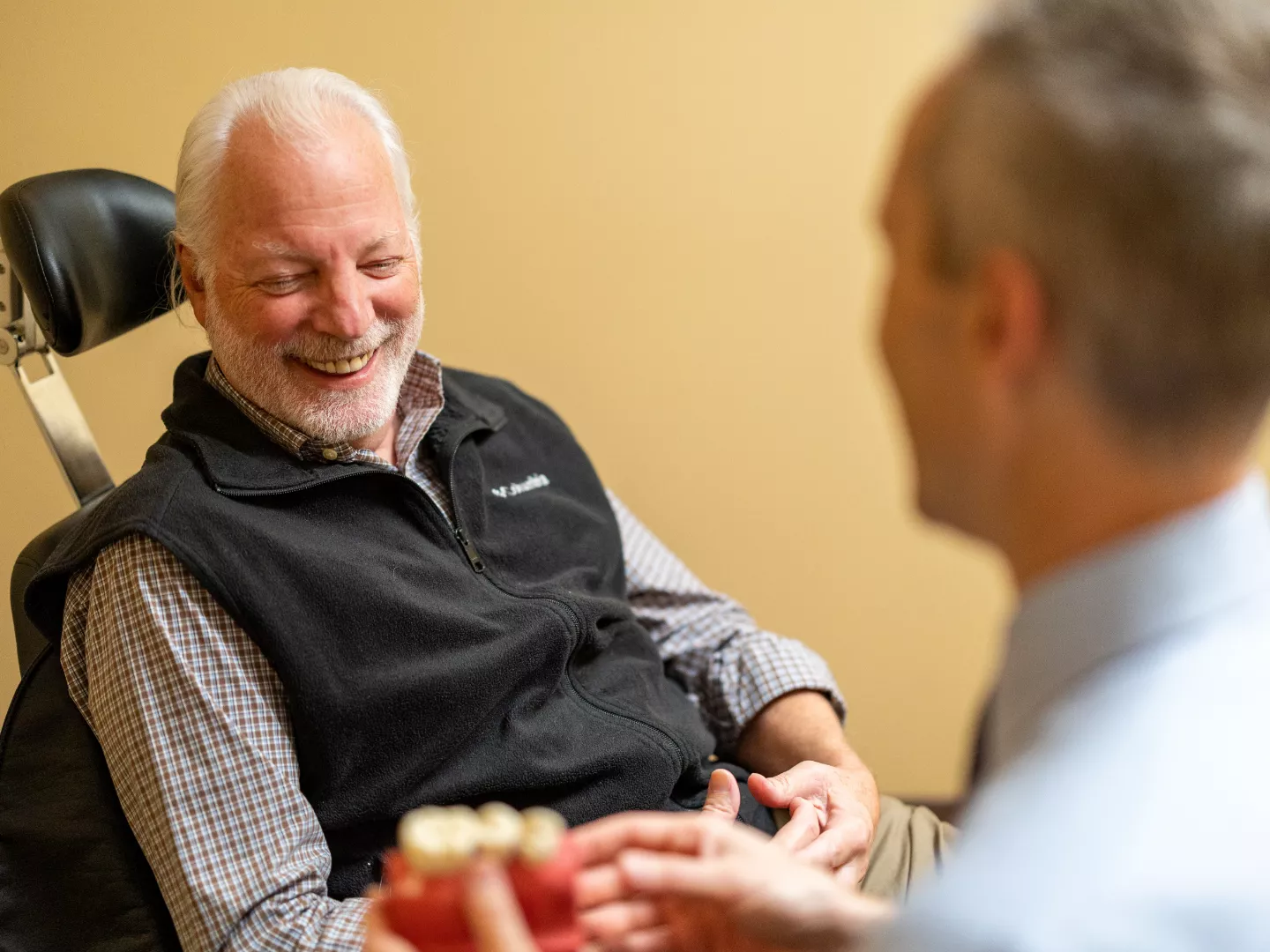 A patient smiles while talking to Dr. Young.
