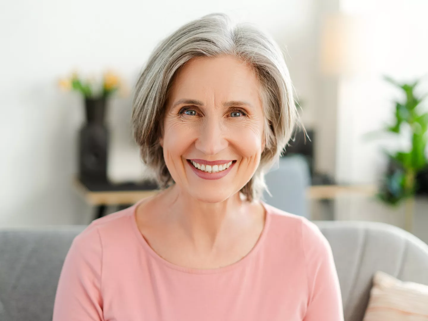 A woman smiling comfortably from home.